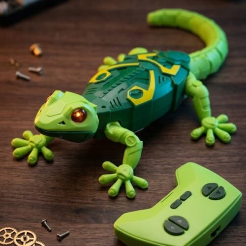 Retail packaging box for the K.LAL Geckos Telecontrol wall-climbing RC toy. The black box displays a bright green robotic gecko with glowing red eyes, alongside text highlighting features like a 2.4 GHz control system, 360-degree spinning on the wall, and an ages 4+ rating.