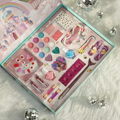 Top-down view of a fairytale-themed girls makeup play set in its box, highlighting press-on nails, a mermaid-shaped makeup brush, heart glitters, and a built-in mirror on the lid.