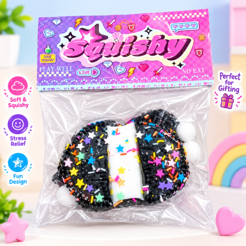 A black squishy toy decorated with colorful star and line sprinkles and white pom-poms, packaged in a clear bag with a retro pixelated "Squishy" header card.