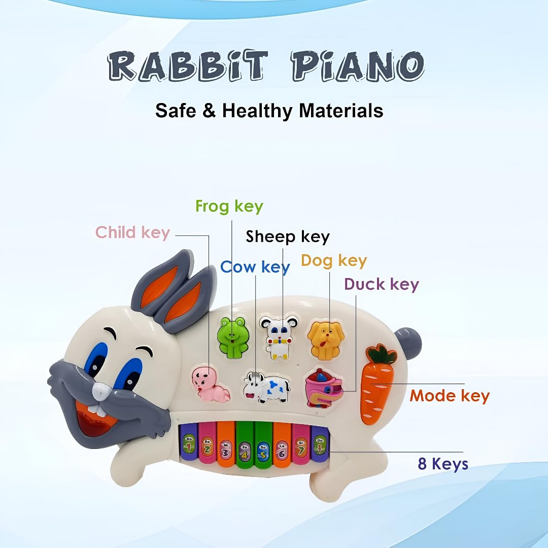 A white plastic musical toy shaped like a rabbit, featuring 8 colorful piano keys along the bottom, a carrot-shaped mode key, and six interactive character buttons shaped like a child, frog, sheep, cow, dog, and duck. Text at the top reads "RABBIT PIANO - Safe & Healthy Materials".
